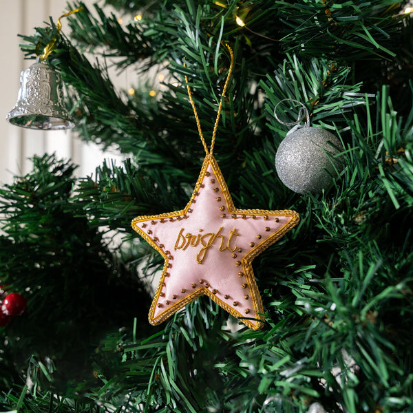 Star-shaped ornament with 'bright' text on a Christmas tree